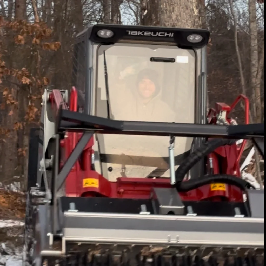 Outdoor Organics veteran shown mulching overgrown land using the Takeuchi tractor.