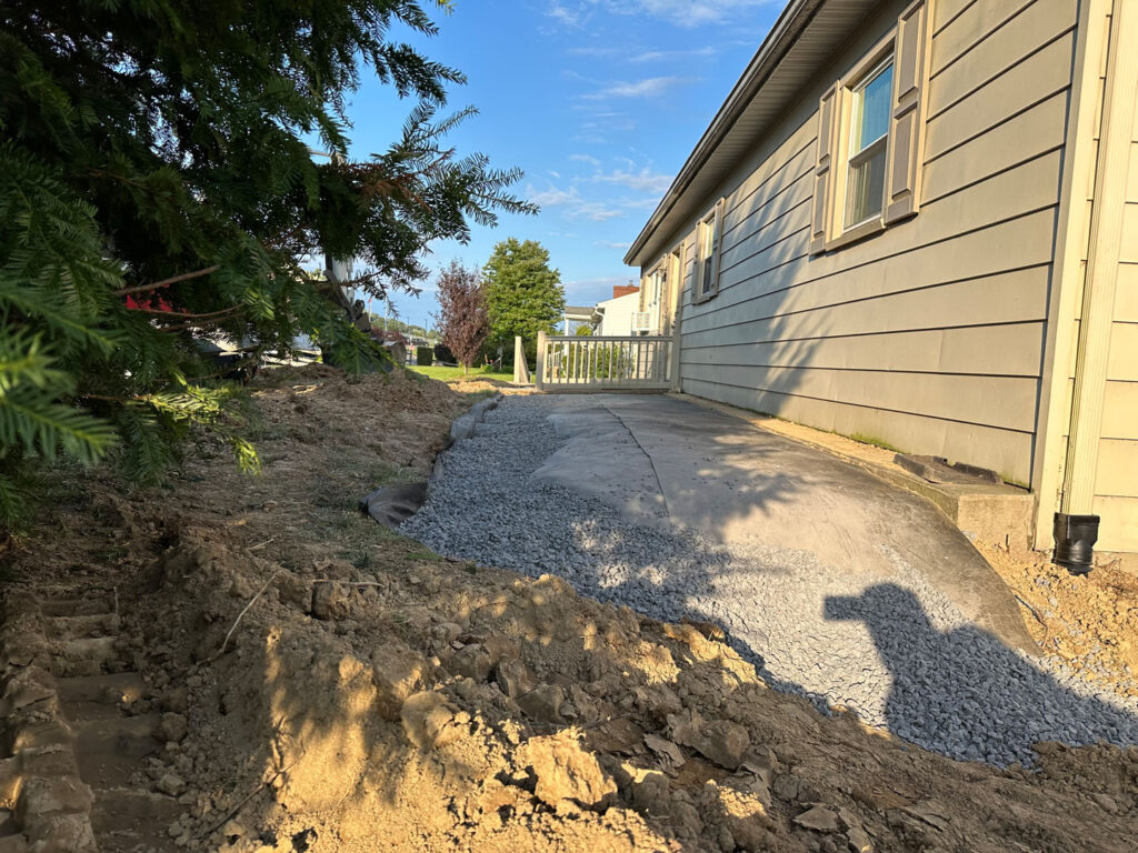 Covered new drainage with decorative river rock for added visual appeal.